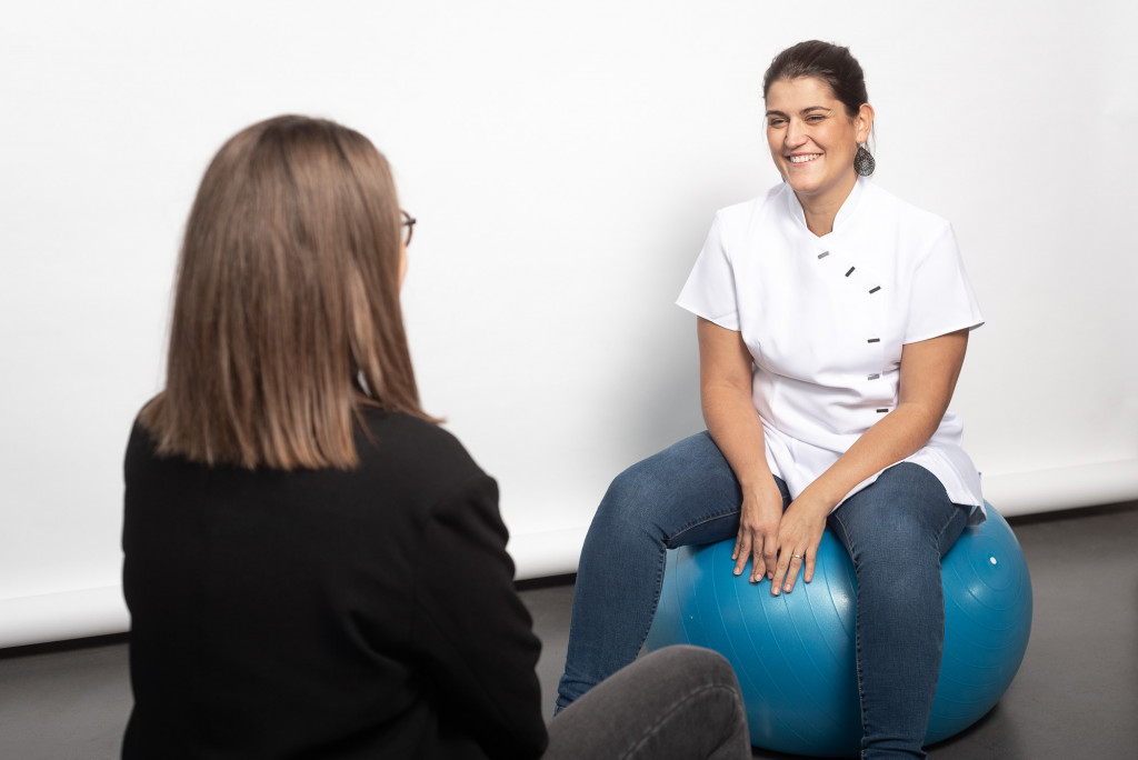 Une sage femme et sa patiente assises sur des balles de fitness